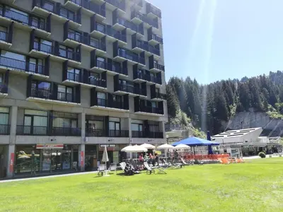 a large building with chairs and umbrellas in the grass at Résidence Aldébaran - maeva Home - Appartement 2 Pièces 6 Personnes - Confort MAE-3806 in Arâches-la-Frasse