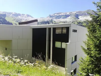 a building on a hill with mountains in the background at Résidence Castor - maeva Home - Appartement 2 Pièces 6 Personnes - Confort MAE-3847 in Arâches-la-Frasse
