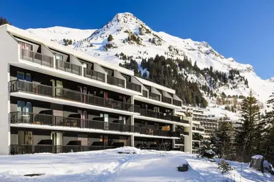 a building with a snow covered mountain in the background at Résidence Castor - maeva Home - Appartement 2 Pièces 6 Personnes - Confort MAE-3850 in Arâches-la-Frasse