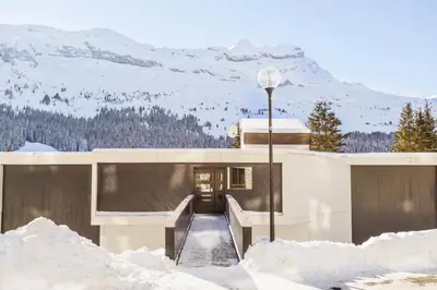 a building with a snow covered mountain in the background at Résidence Castor - maeva Home - Appartement 2 Pièces 6 Personnes - Confort MAE-3850 in Arâches-la-Frasse