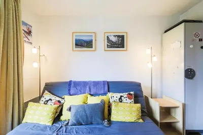 a blue couch with yellow pillows in a room at Résidence Sirius - maeva Home - Studio 4 Personnes - Confort MAE-3896 in Arâches-la-Frasse