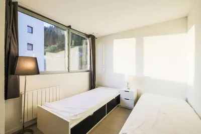 a small room with two beds and a window at Résidence La Petite Ourse - maeva Home - Appartement 4 Pièces 6 Personnes - Sélection MAE-3904 in Arâches-la-Frasse