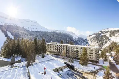 a person skiing in the snow in front of a hotel at Résidence Cassiopée - maeva Home - Appartement 2 Pièces 6 Personnes - Sélection MAE-3948 in Arâches-la-Frasse