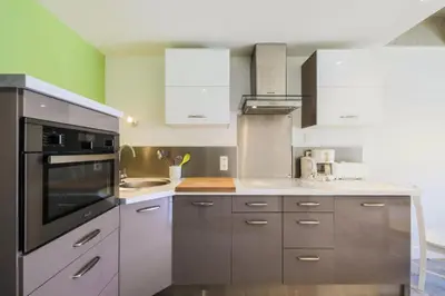 a kitchen with stainless steel appliances and white cabinets at Résidence Cassiopée - maeva Home - Appartement 2 Pièces 6 Personnes - Sélection MAE-3948 in Arâches-la-Frasse