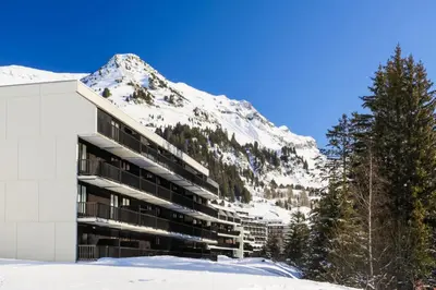 a building with a snow covered mountain in the background at Résidence Pollux - maeva Home - Appartement 2 pièces 6 personnes - Budget MAE-4210 in Arâches-la-Frasse