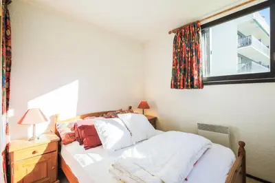 a bedroom with a bed with white sheets and a window at Résidence Pollux - maeva Home - Appartement 2 pièces 6 personnes - Budget MAE-4210 in Arâches-la-Frasse