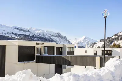 a building in the snow with mountains in the background at Résidence Pollux - maeva Home - Studio 4 personnes - Budget MAE-4213 in Arâches-la-Frasse