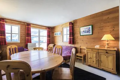 a dining room with a wooden table and chairs at Résidence Le Château de Crans - maeva Home - Appartement 3 Pièces 10 Personnes - Budget MAE-4252 in Flaine