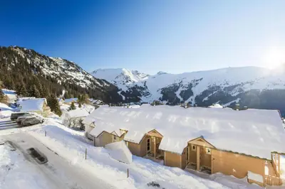 a house covered in snow with mountains in the background at Résidence Le Château de Crans - maeva Home - Appartement 3 Pièces 10 Personnes - Budget MAE-4252 in Flaine