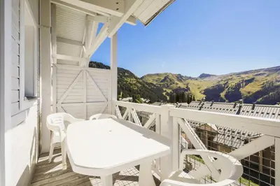a white table and chairs on a balcony with mountains at Résidence Le Château de Crans - maeva Home - Appartement 3 Pièces 10 Personnes - Budget MAE-4252 in Flaine