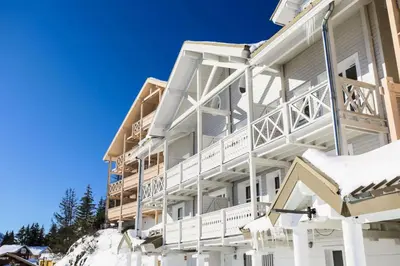 a white apartment building with snow on the ground at Résidence Le Château de Crans - maeva Home - Appartement 2 Pièces 6 Personnes - Prestige MAE-4253 in Flaine