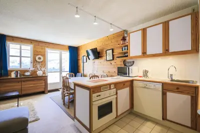 a kitchen with wooden walls and a table in a room at Résidence Le Château de Crans - maeva Home - Appartement 2 Pièces 6 Personnes - Prestige MAE-4253 in Flaine