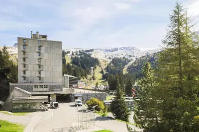 a building on a hill with mountains in the background at Résidence Véga - maeva Home - Studio 4 Personnes - Budget MAE-4467 in Arâches-la-Frasse
