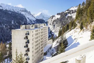a hotel with snow covered mountains in the background at Résidence Véga - maeva Home - Studio 4 Personnes - Budget MAE-4467 in Arâches-la-Frasse