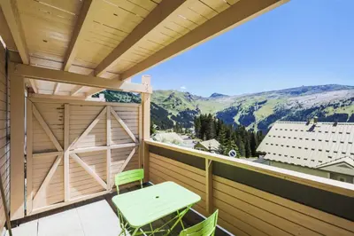 a balcony with a table and chairs and mountains at Résidence Le Château de Crans - maeva Home - Studio 4 Personnes - Confort MAE-4490 in Flaine