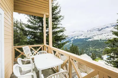 a balcony with a table and chairs and mountains at Résidence Arbaron - maeva Home - Appartement 3 Pièces 8 Personnes - Budget MAE-4591 in Flaine