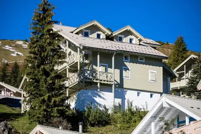 a large house with a balcony and a tree at Résidence Arbaron - maeva Home - Appartement 3 Pièces 8 Personnes - Budget MAE-4591 in Flaine