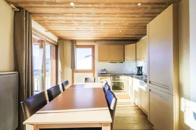a kitchen with a wooden table and chairs at Résidence Refuge du Golf - maeva Home - Appartement 4 Pièces 8 Personnes - Prestige MAE-5505 in Arâches-la-Frasse