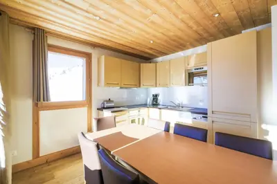 a kitchen with a wooden table and a wooden ceiling at Résidence Refuge du Golf - maeva Home - Appartement 4 Pièces 8 Personnes - Prestige MAE-5505 in Arâches-la-Frasse