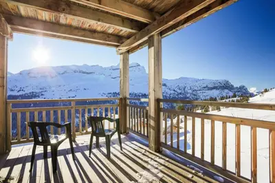 a balcony with two chairs and a view of snow covered mountains at Résidence Refuge du Golf - maeva Home - Appartement 4 Pièces 8 Personnes - Prestige MAE-5505 in Arâches-la-Frasse