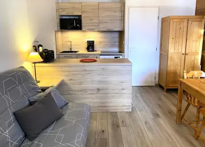 a living room with a couch and a kitchen at Résidence Le Château de Crans - maeva Home - Studio 4 Personnes - Confort MAE-9176 in Flaine