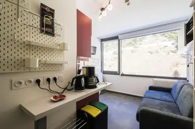 a room with a couch and a table and a window at Résidence Bellatrix - maeva Home - Studio 2 Personnes - Confort MAE-2104 in Flaine
