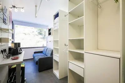 a room with white shelves and a blue couch at Résidence Bellatrix - maeva Home - Studio 2 Personnes - Confort MAE-2104 in Flaine