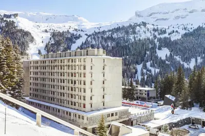 a large building in the snow with a mountain at Résidence Cassiopée - maeva Home - Appartement 4 pièces 6 personnes - Confort MAE-3654 in Arâches-la-Frasse