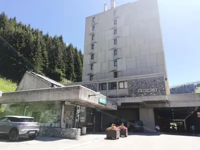 a building with a car parked in a parking lot at Résidence Cassiopée - maeva Home - Appartement 4 pièces 6 personnes - Confort MAE-3654 in Arâches-la-Frasse