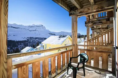 a chair on a balcony with a view of the mountains at Résidence Refuge du Golf - maeva Home - Chalet 4 Pièces 8 Personnes - Prestige MAE-3884 in Arâches-la-Frasse