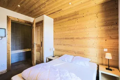 a bedroom with a bed and a wooden wall at Résidence Refuge du Golf - maeva Home - Chalet 4 Pièces 8 Personnes - Prestige MAE-3884 in Arâches-la-Frasse
