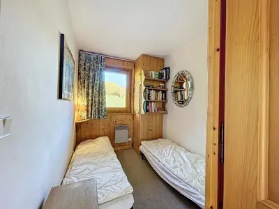 two beds in a small room with a window at Appartement Mont Blanc : 2 chambres, terrasse, parking et équipements modernes - FR-1-560-131 in Demi-Quartier