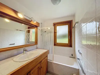 a bathroom with a sink and a tub and a mirror at Appartement Mont Blanc : 2 chambres, terrasse, parking et équipements modernes - FR-1-560-131 in Demi-Quartier