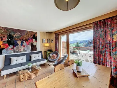 a living room with a couch and a table at Appartement Mont Blanc : 2 chambres, terrasse, parking et équipements modernes - FR-1-560-131 in Demi-Quartier