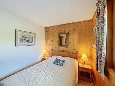 a small bedroom with a bed and two lamps at Appartement Mont Blanc : 2 chambres, terrasse, parking et équipements modernes - FR-1-560-131 in Demi-Quartier