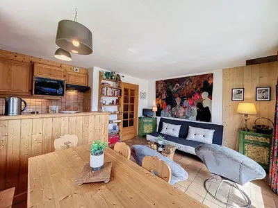 a living room with a table and a couch at Appartement Mont Blanc : 2 chambres, terrasse, parking et équipements modernes - FR-1-560-131 in Demi-Quartier