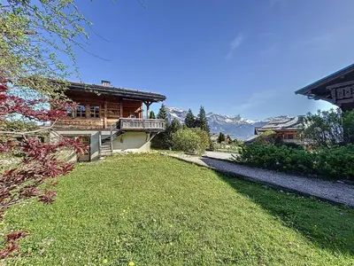 a house with a balcony and a grass yard at Superbe chalet au calme avec jardin, garage et Wifi - FR-1-560-130 in Combloux