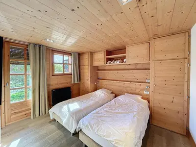 a bedroom with a bed in a wooden room at Superbe chalet au calme avec jardin, garage et Wifi - FR-1-560-130 in Combloux