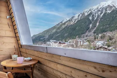 a balcony with a table and a view of a mountain at Appartement 