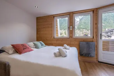 a large white bed in a room with windows at Appartement 