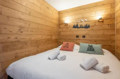 a bedroom with a white bed with wooden walls at Appartement 