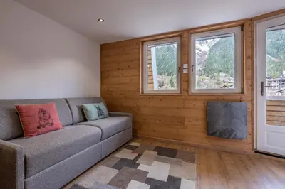 a living room with a couch and windows at Appartement 