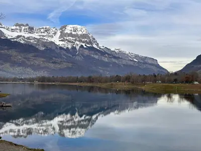 a mountain reflection in a lake with a mountain at Studio de 31m² idéalement situé aux pieds des remontées mécaniques été/hiver in Saint-Gervais-les-Bains