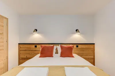 a bedroom with a large bed with two pillows at White Pearl A03 - Alpes Travel - Central Chamonix - Sleeps 2-4 in Chamonix-Mont-Blanc