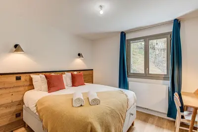a bedroom with a large bed and a window at White Pearl A03 - Alpes Travel - Central Chamonix - Sleeps 2-4 in Chamonix-Mont-Blanc
