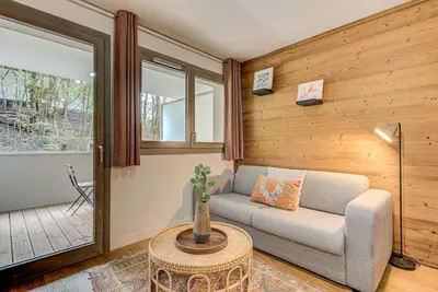 a living room with a couch and a table at White Pearl A03 - Alpes Travel - Central Chamonix - Sleeps 2-4 in Chamonix-Mont-Blanc