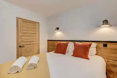 a bedroom with a large bed with two towels on it at White Pearl A03 - Alpes Travel - Central Chamonix - Sleeps 2-4 in Chamonix-Mont-Blanc