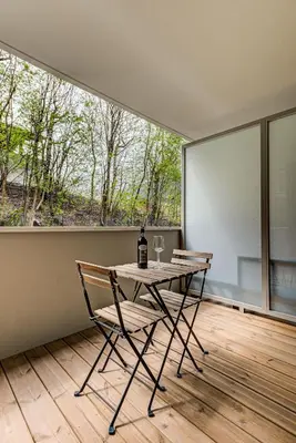 a table with two chairs and a bottle of wine at White Pearl A03 - Alpes Travel - Central Chamonix - Sleeps 2-4 in Chamonix-Mont-Blanc
