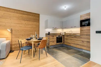 a kitchen and dining room with a table and chairs at White Pearl A03 - Alpes Travel - Central Chamonix - Sleeps 2-4 in Chamonix-Mont-Blanc