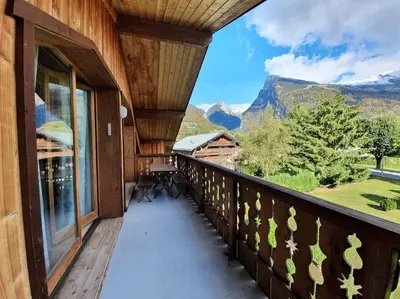 a balcony of a house with a view of mountains at C11, 72m2, 3 bedrooms, next to the ski lift in Samoëns